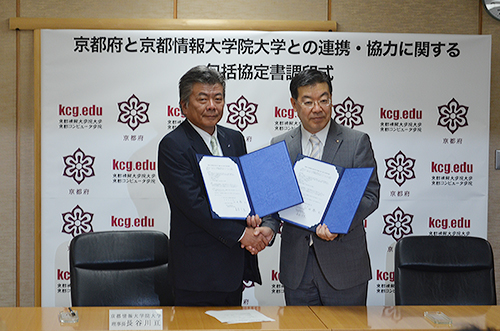 Wataru Hasegawa, Dean of KCGI (left), and Keiji Yamada, Governor of Kyoto Prefecture, shake hands after signing a comprehensive agreement on collaboration and cooperation between KCGI and Kyoto Prefecture on May 26, 2015 at the Kyoto Prefectural Office.